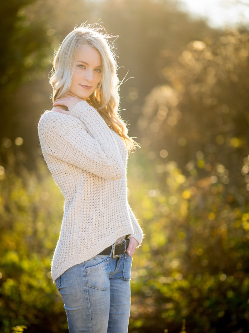 Blonde woman wearing a sweater and jeans