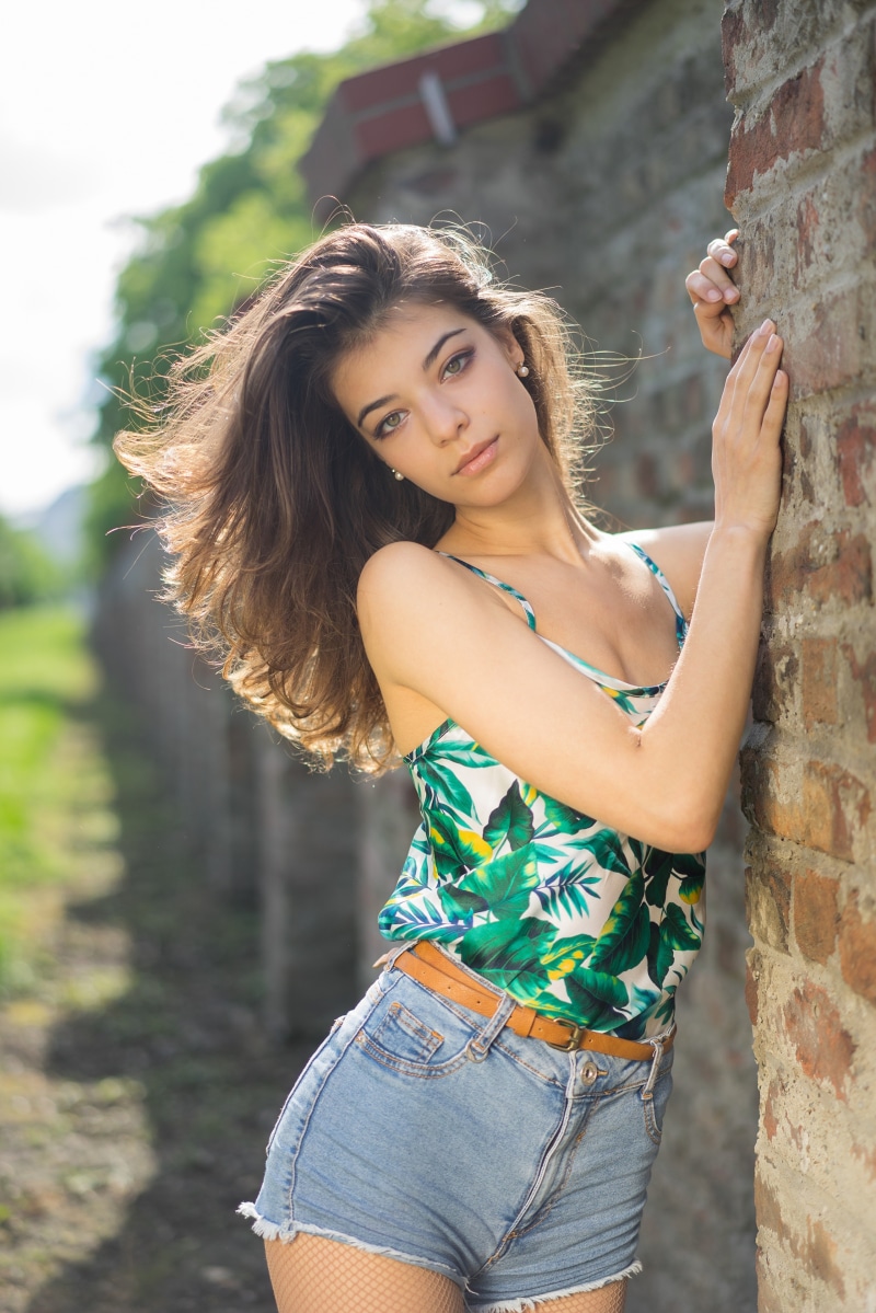 Ana leaning against a brick wall