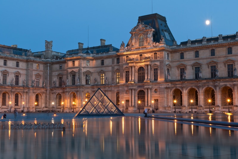 Louvre Museum at dusk with pyramid and moon