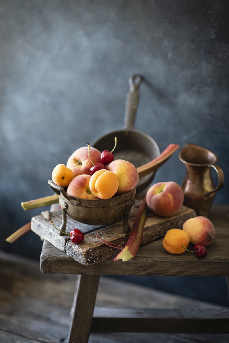 Still life of peaches, apricots, cherries, and rhubarb