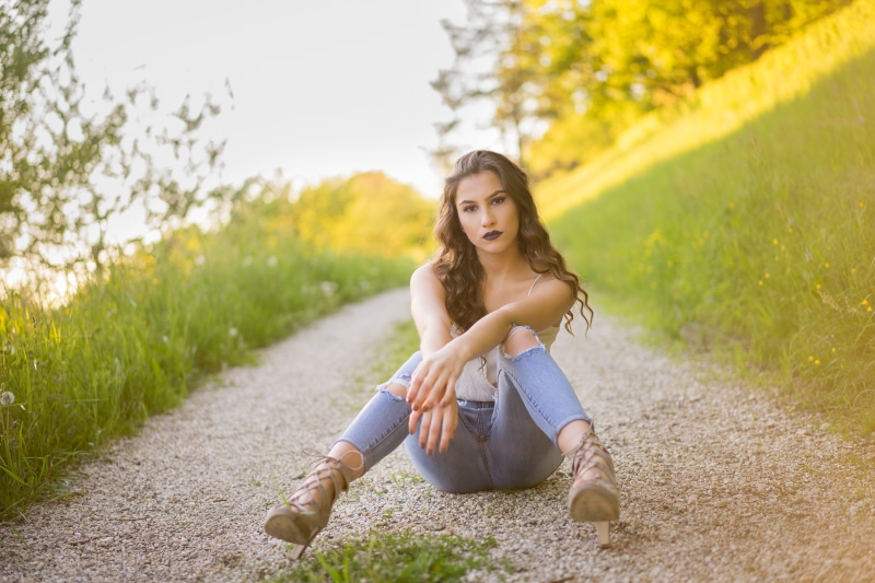 Jasmin with brown hair sitting on a path