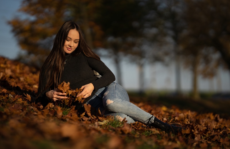 Anastasia lying in autumn foliage