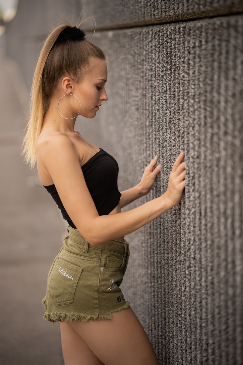 Sara leaning against a textured wall