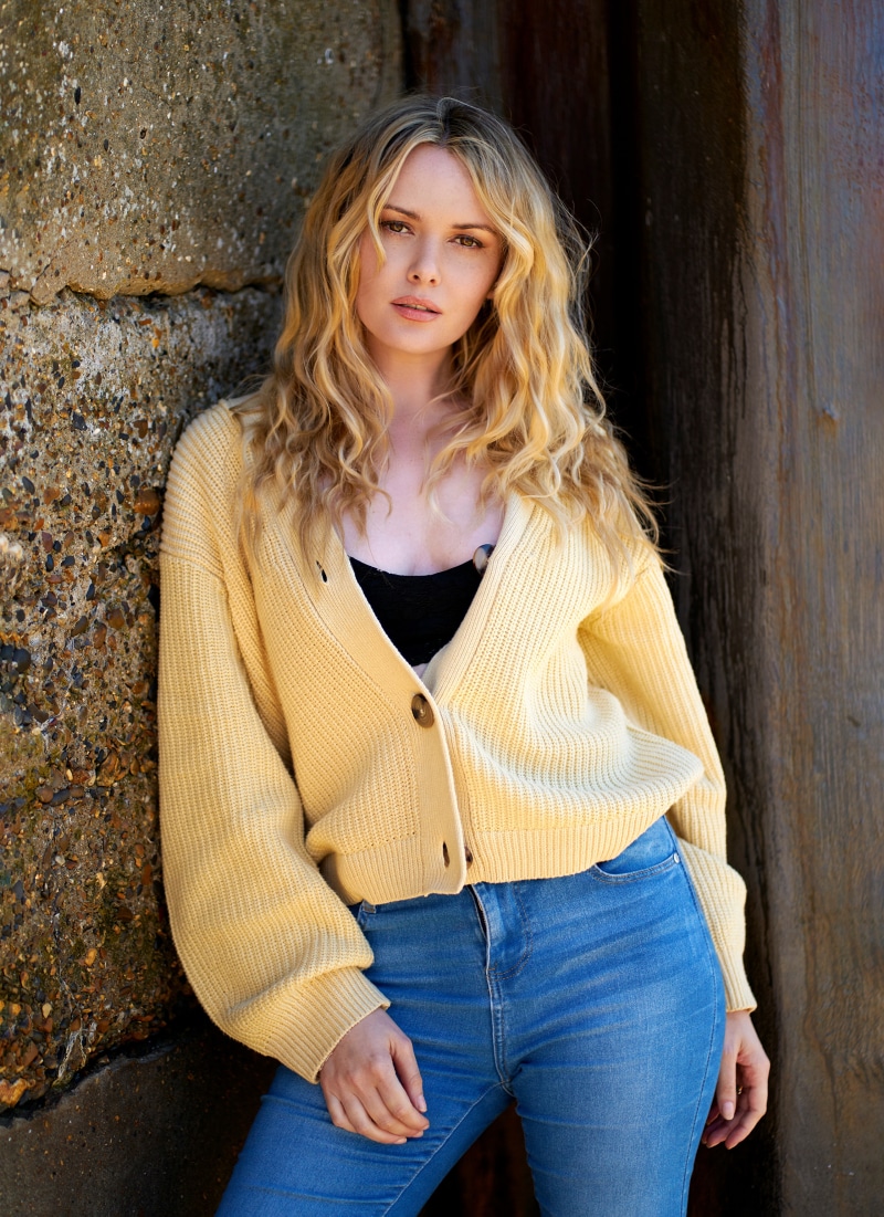 Carla Monaco blonde woman in yellow cardigan and jeans