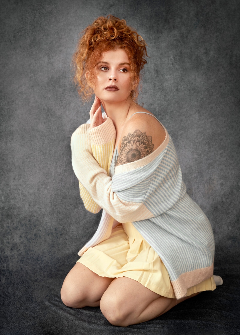 Redhead woman kneeling with tattoo