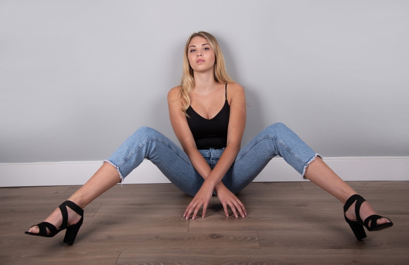 Mia Chagnon sitting on floor in jeans and singlet