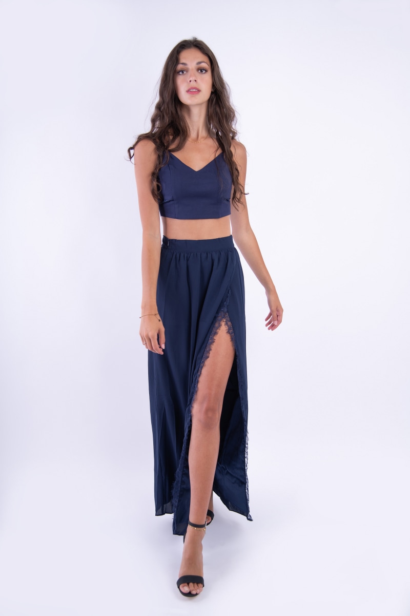 Woman in navy blue crop top and skirt