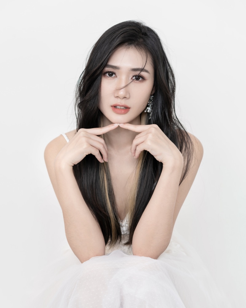 Brunette girl with hands near face