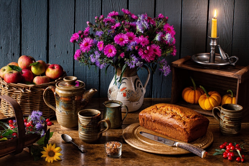 Still-life with apples, bread, flowers, and candle
