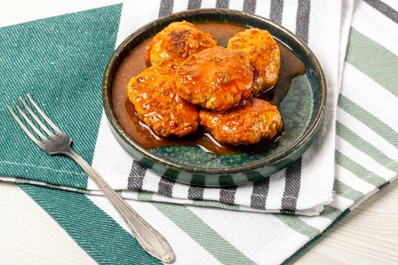 Frikadeller in sauce with a fork