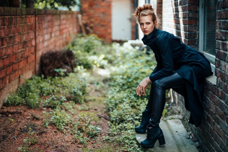 Julia Kruse sitting by a brick wall