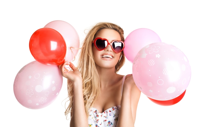 Blonde girl with heart sunglasses holding balloons
