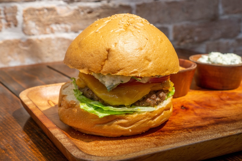 Hamburger with cheese and lettuce on a wooden board
