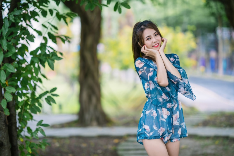 Asian woman smiling and posing in a park