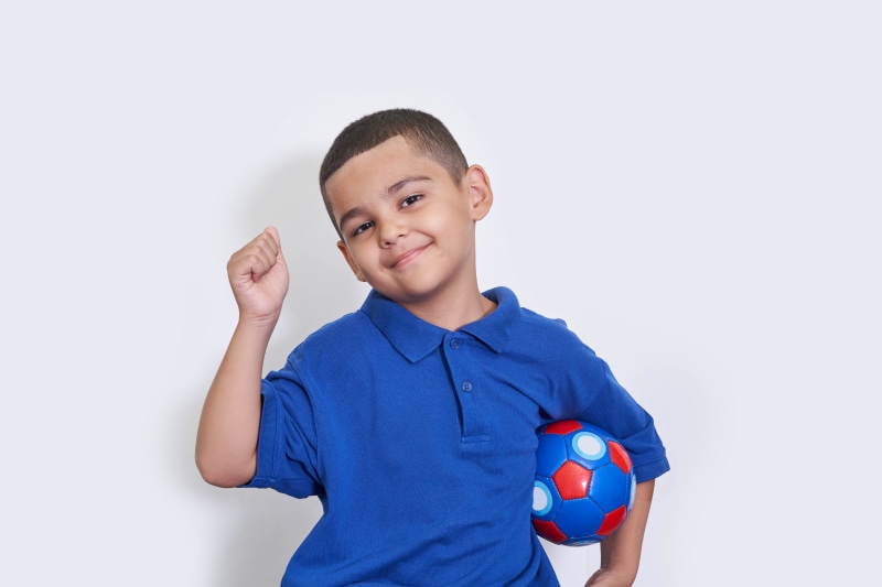 Boy with soccer ball and raised fist