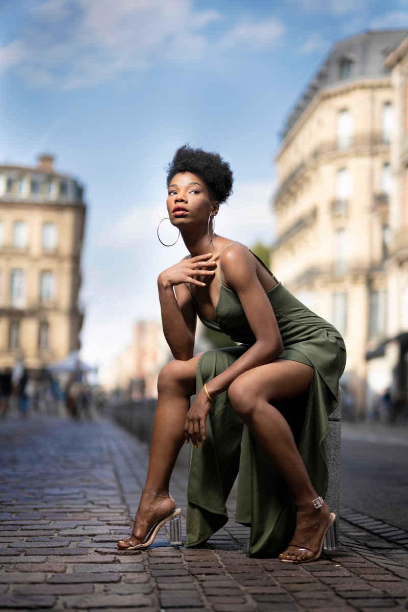 Woman in a green dress sitting on a stone