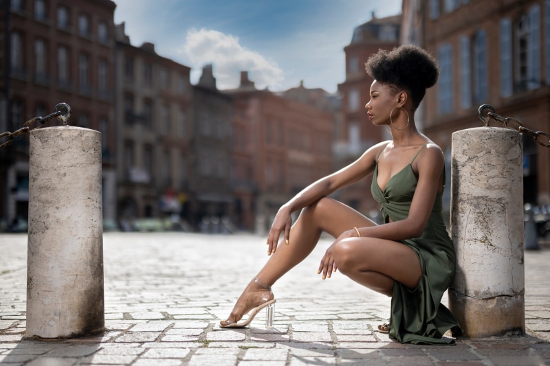 Woman in green dress posing in city square