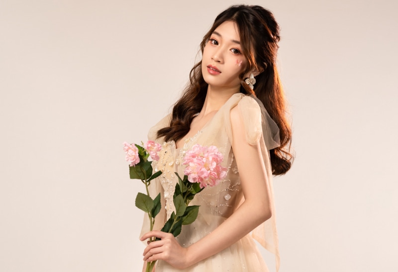 Asian woman holding pink flowers