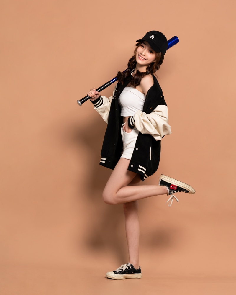 Asian girl in baseball cap holding baseball bat