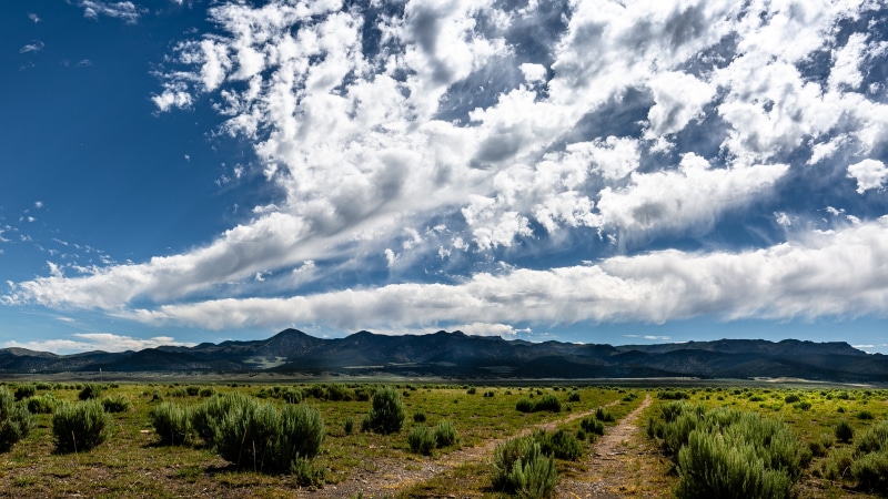 Sagebrush fields and mountains under a cloudy sky in Panguitch, USA