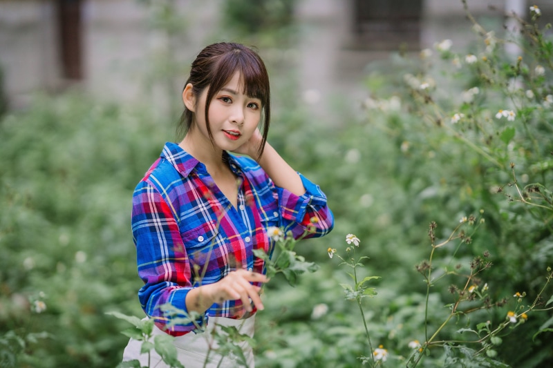 Asian woman in plaid shirt in garden