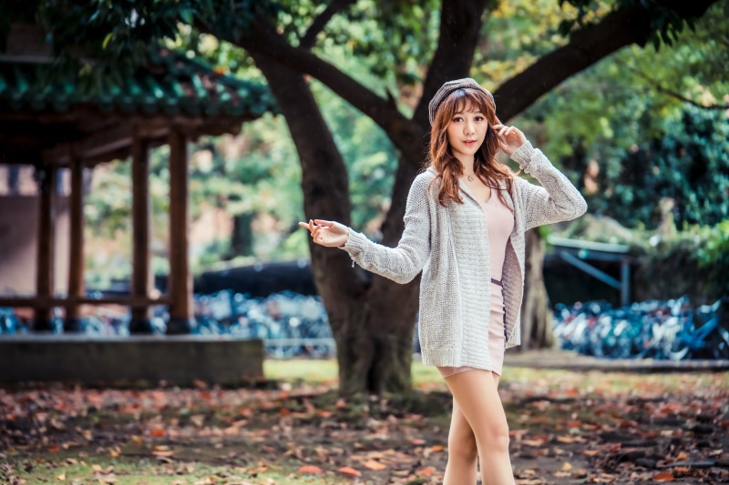 Asian woman in a park with a building and bicycles