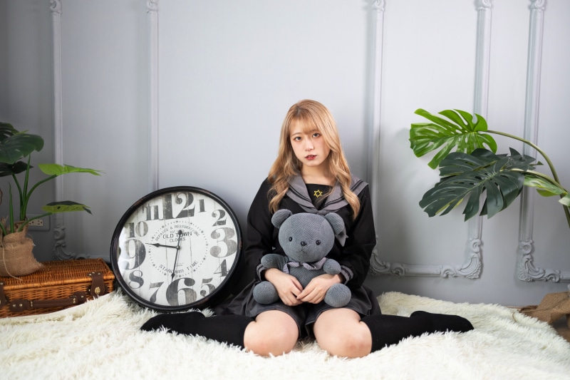 Asian girl with teddy bear and clock