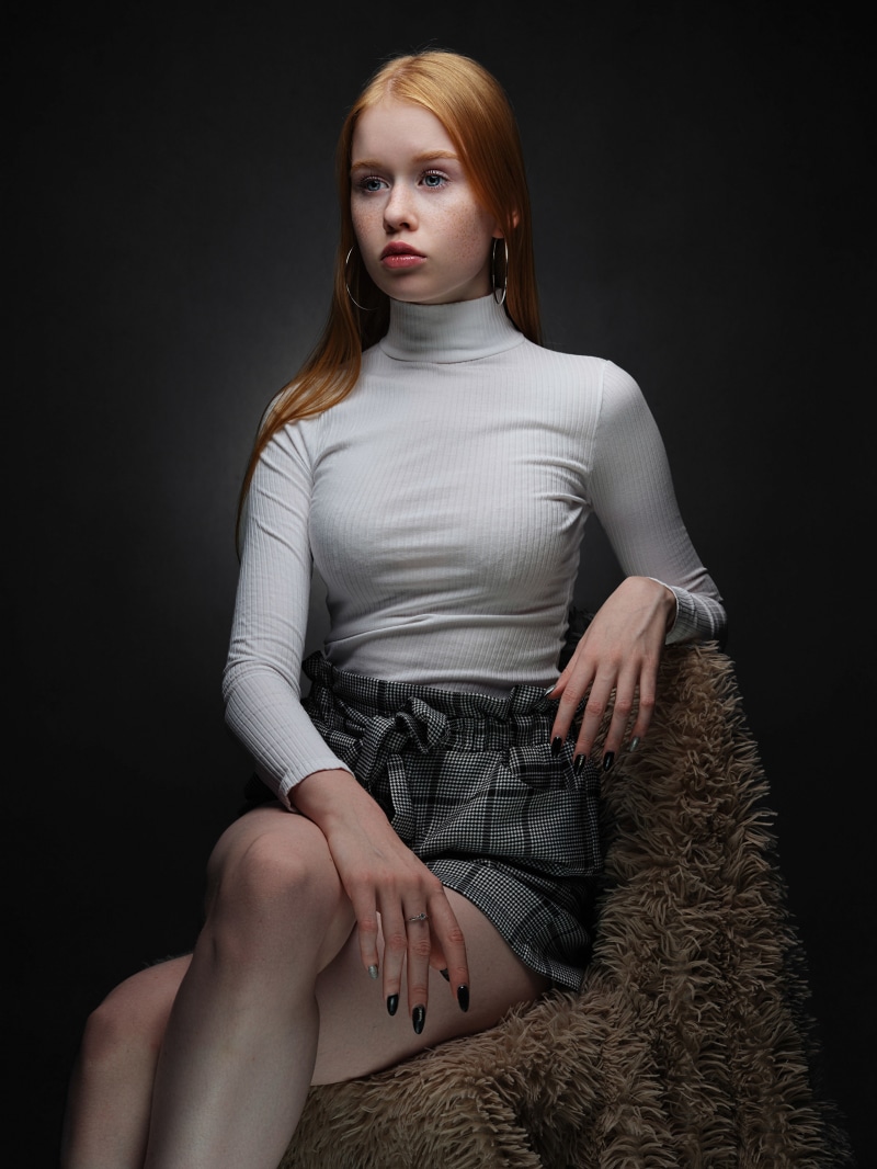 Redhead girl sitting on a chair