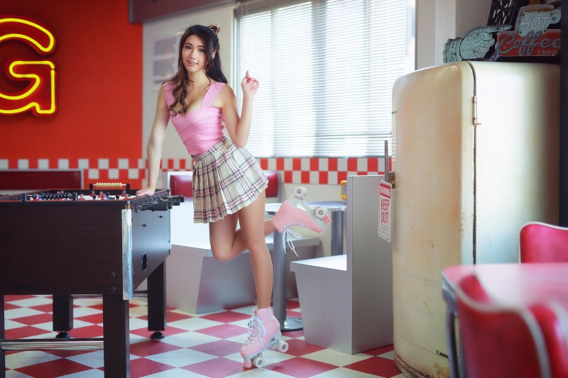 Asian woman in roller skates and skirt