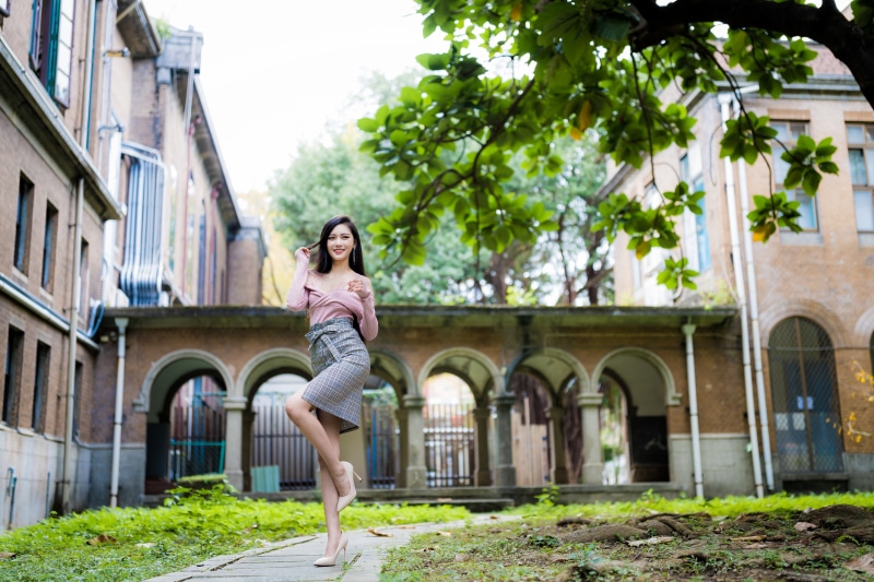 Asian woman posing in front of a building