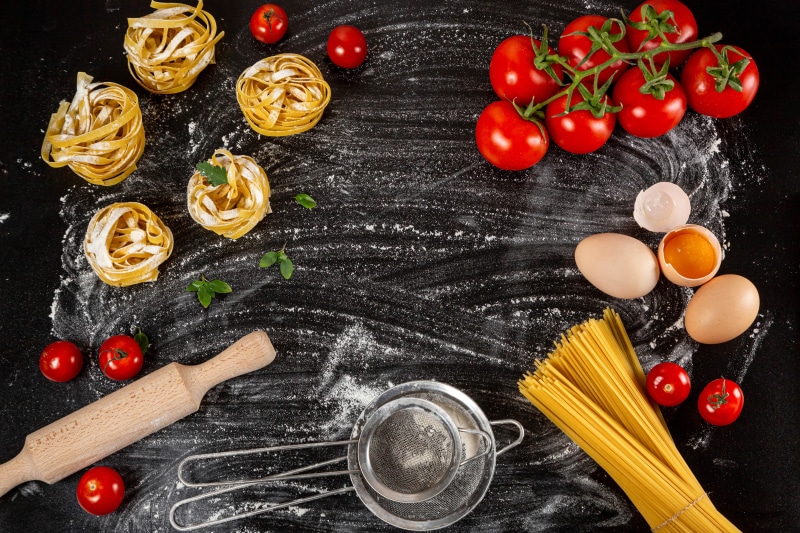Pasta ingredients with tomatoes and eggs on flour