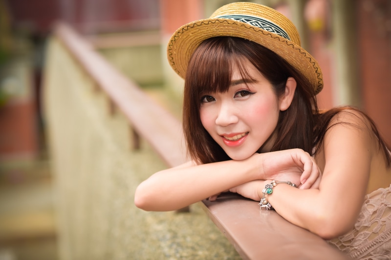 Asian woman with brown hair wearing a hat