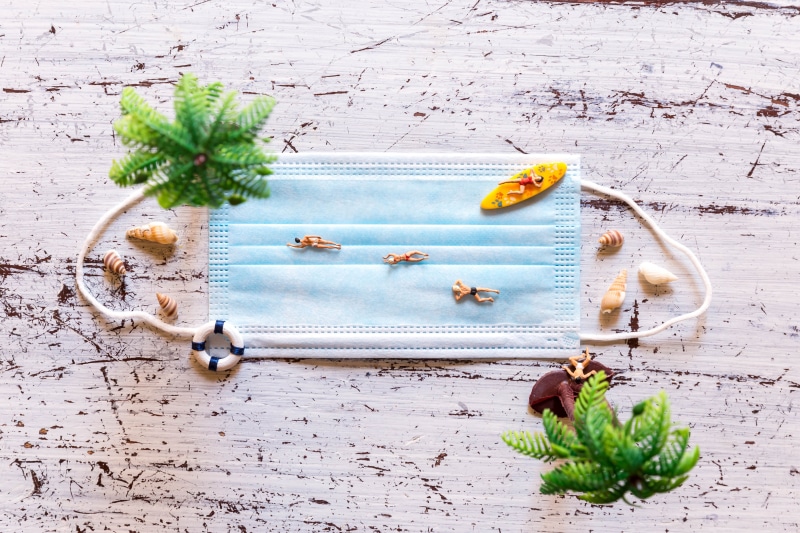 Creative composition of face mask with beach elements