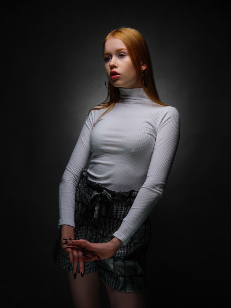 Redhead girl in turtleneck and plaid shorts