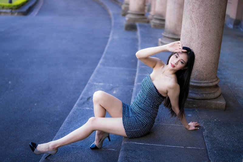 Asian woman in dress sitting on steps