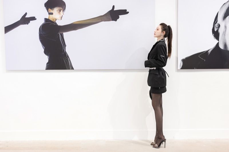 Woman in black blazer looking at art