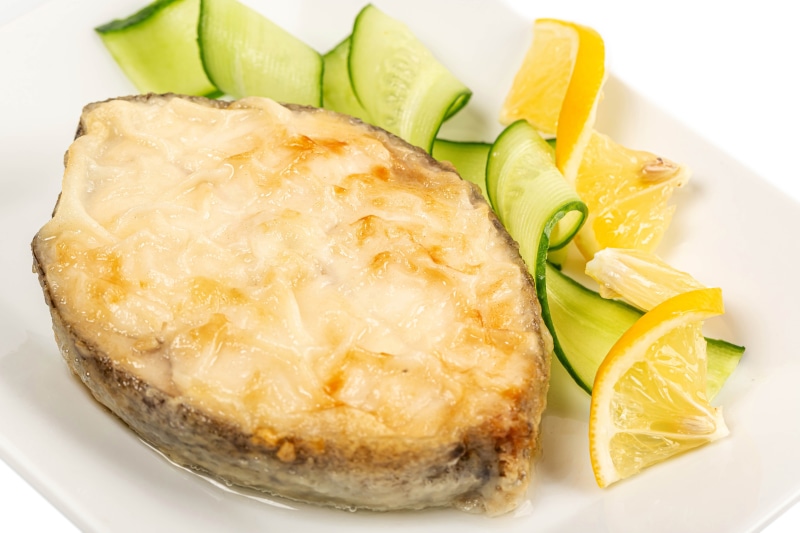 Fried fish steak with cucumber and lemon slices