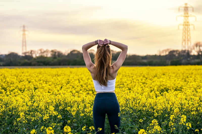 Woman in Rapeseed Field at Sunset