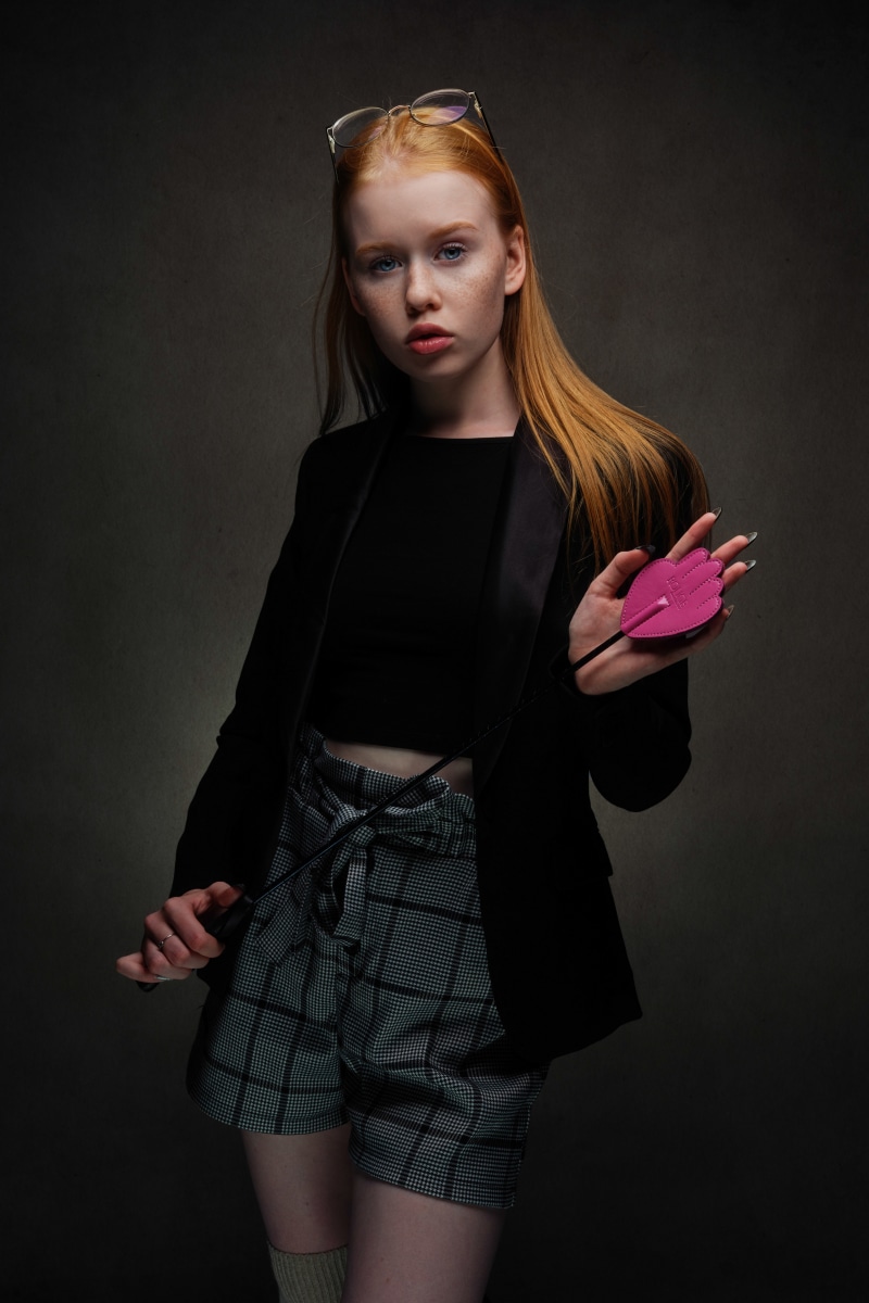 Redhead girl with glasses and a pink paddle