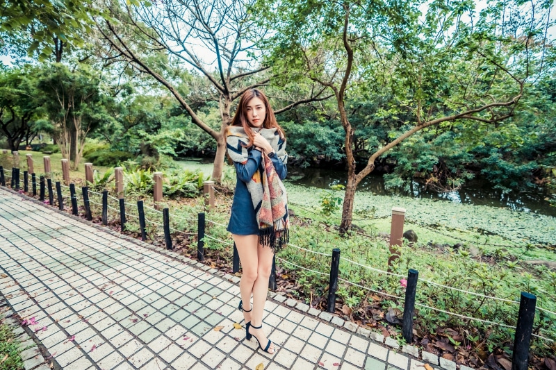 Asian woman in dress and scarf in park