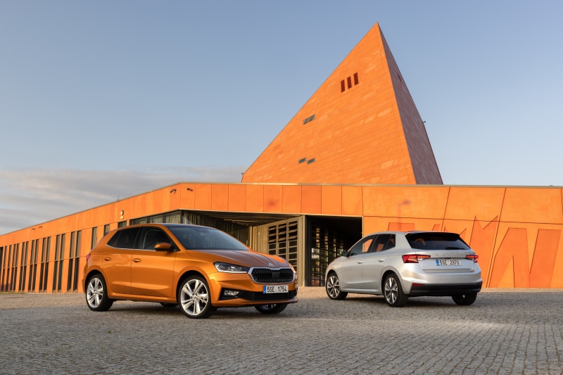 Two Skoda Fabia cars in front of a modern building