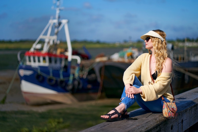 Blonde girl sitting by a boat