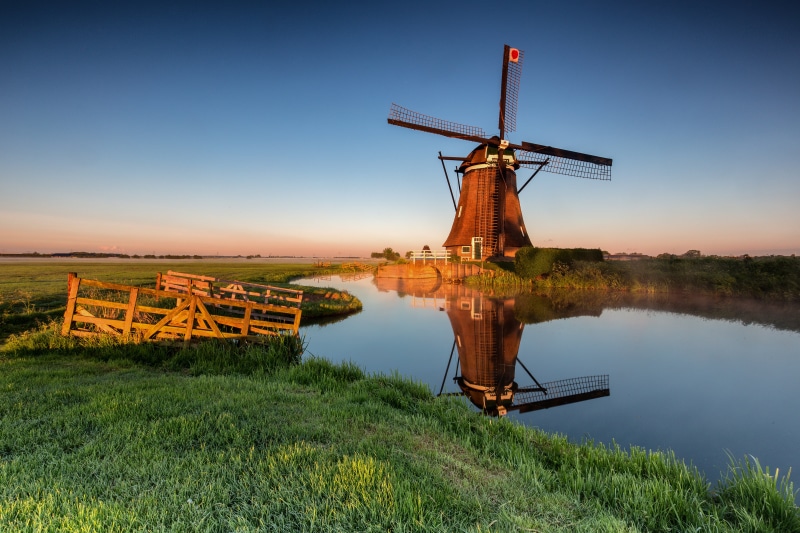 Windmill reflection in canal at sunrise, Alblasserwaard, Netherlands