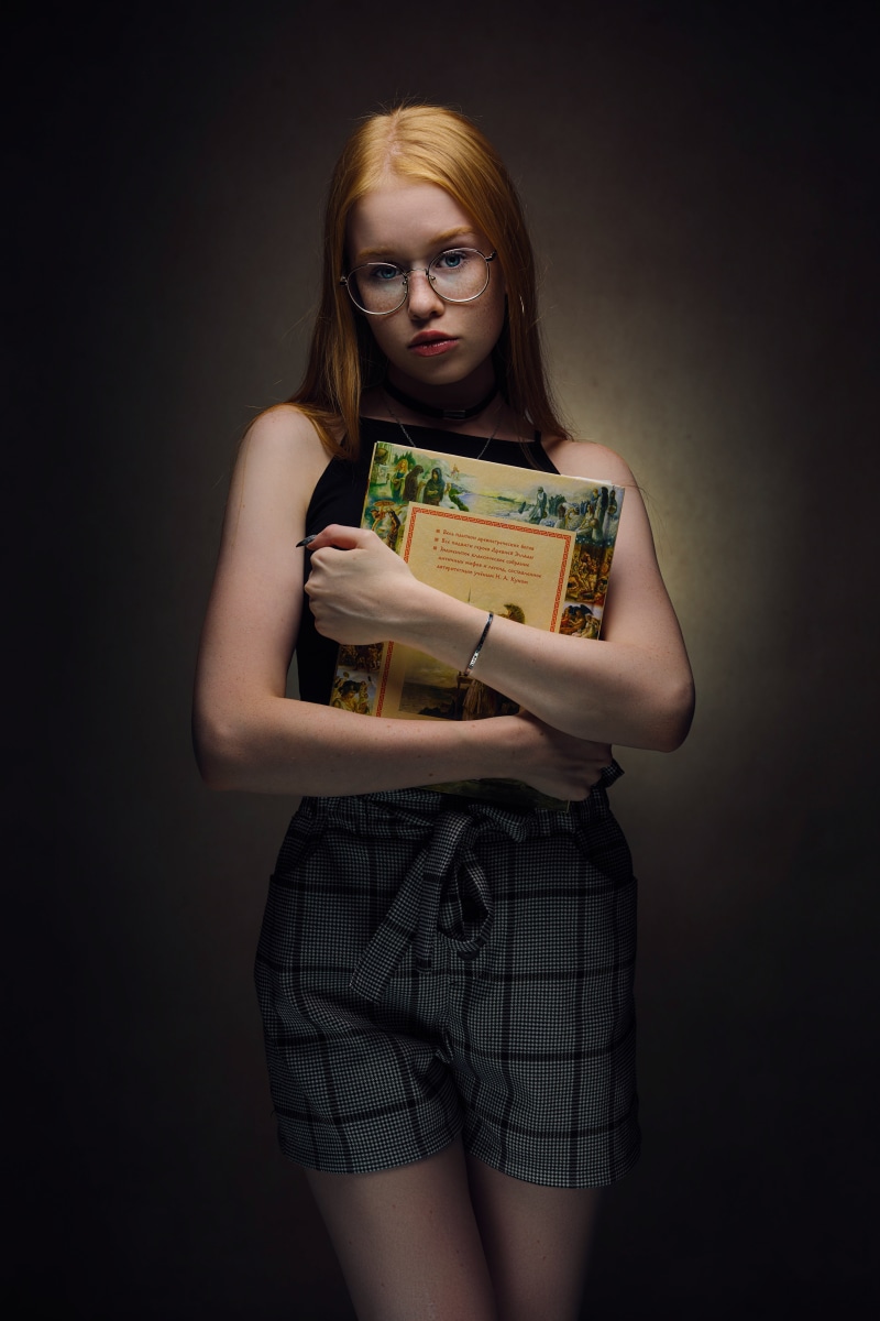 Girl with glasses holding a book