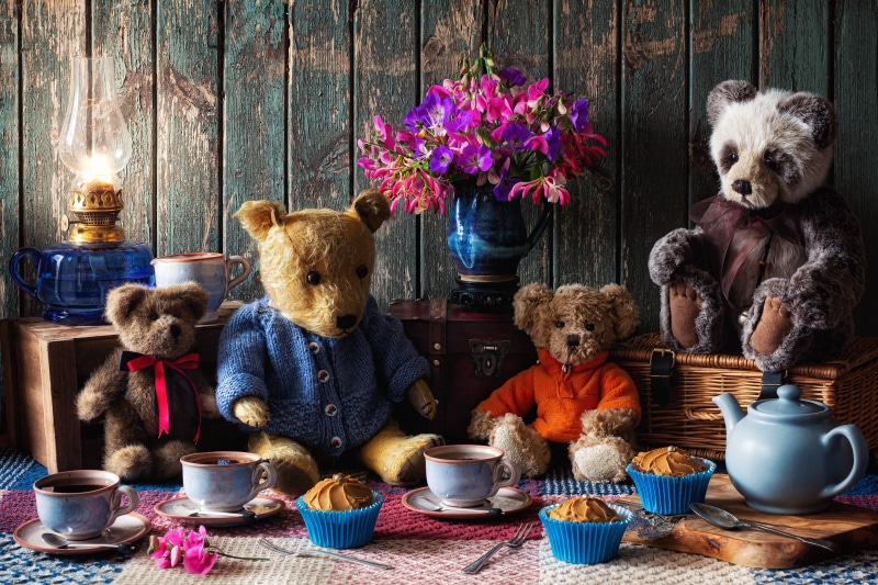 Teddy bears having a tea party with cupcakes