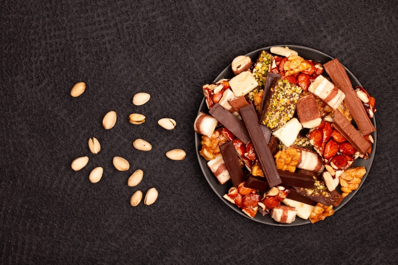 Plate of assorted chocolates and nuts on a gray background