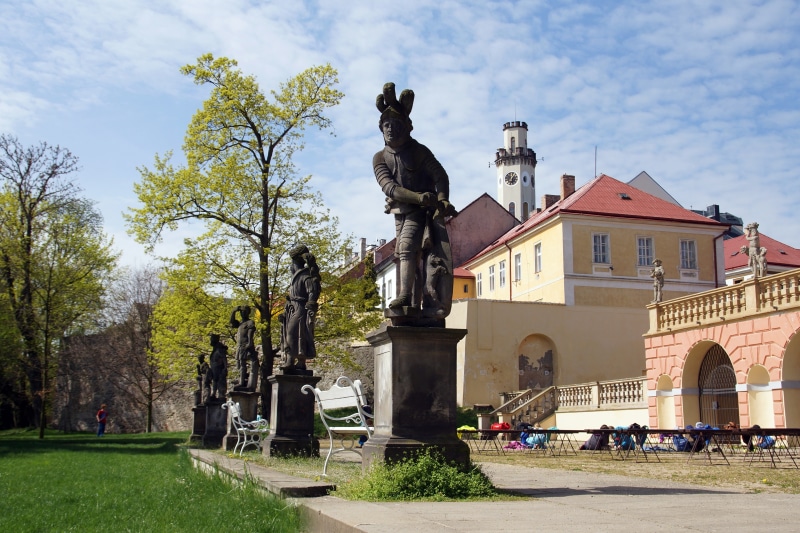 Sculptures in a park with a castle tower in the Czech Republic