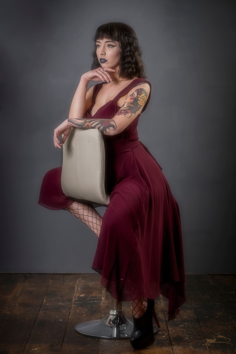 Woman with tattoos sitting on a stool