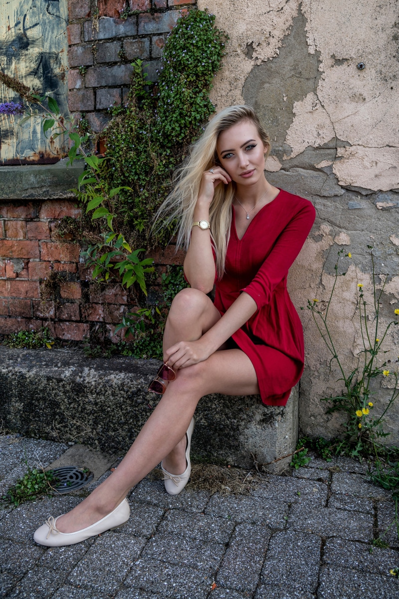 Daria, a blonde model, sitting outdoors