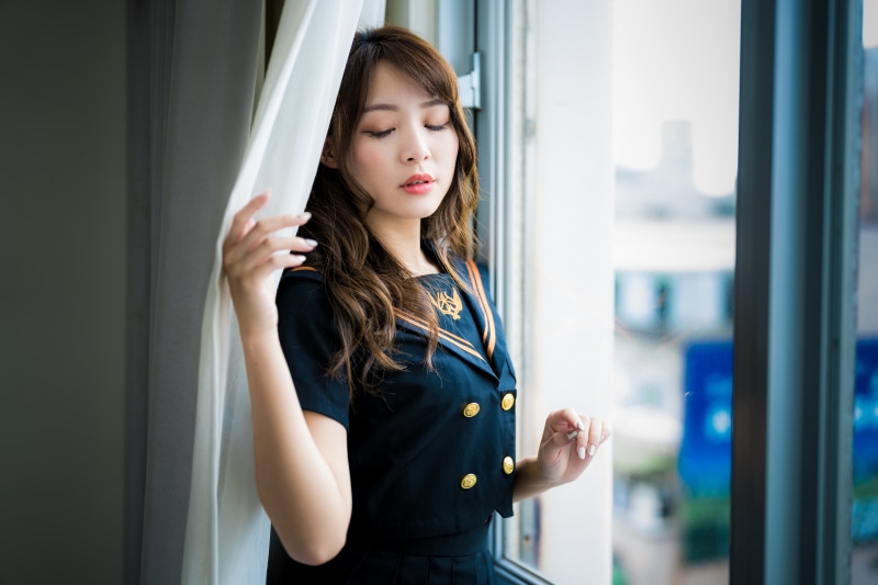 Asian woman in sailor uniform by the window